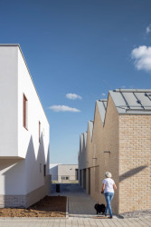 Veřejné budovy mají obklad z režného zdiva, soukromé jsou omítnuté. (Obytný soubor Dolina v Lysolajích, knesl kynčl architekti)