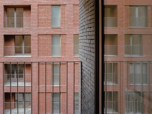 Studio AVENIER CORNEJO architectes navrhlo na břehu kanálu na předměstí Paříže obytný soubor třech domů s různým odstínem lícových cihel