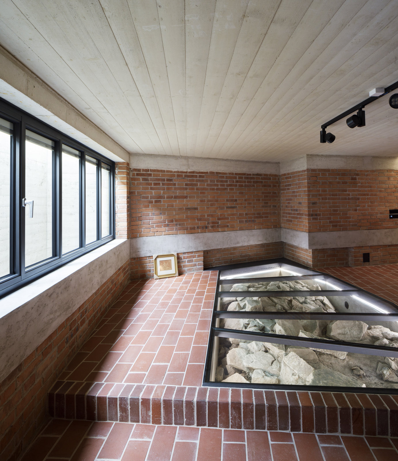 Pozůstatek hradby z 10. století zviditelněný ve společenském prostoru pod vstupní halou galerie. (Bytový dům na Malé Straně; architektonický ateliér Ladislava Lábuse)