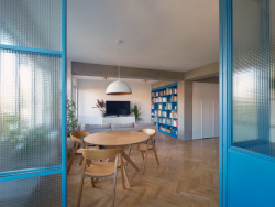 Pohled z pracovny - ta má modře orámované stěny z drátoskla. (Rekonstrukce bytu v Holešovicích; B² Architecture)