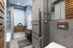 Do koupelny se nakonec podařilo vměstnat i pračku se sušičkou, schované jsou za dřevěnou laťkovou stěnou.