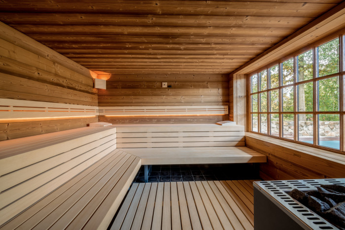 Prostorná soukromá finská sauna adaptovaná na okno s výhledem do zahrady. 