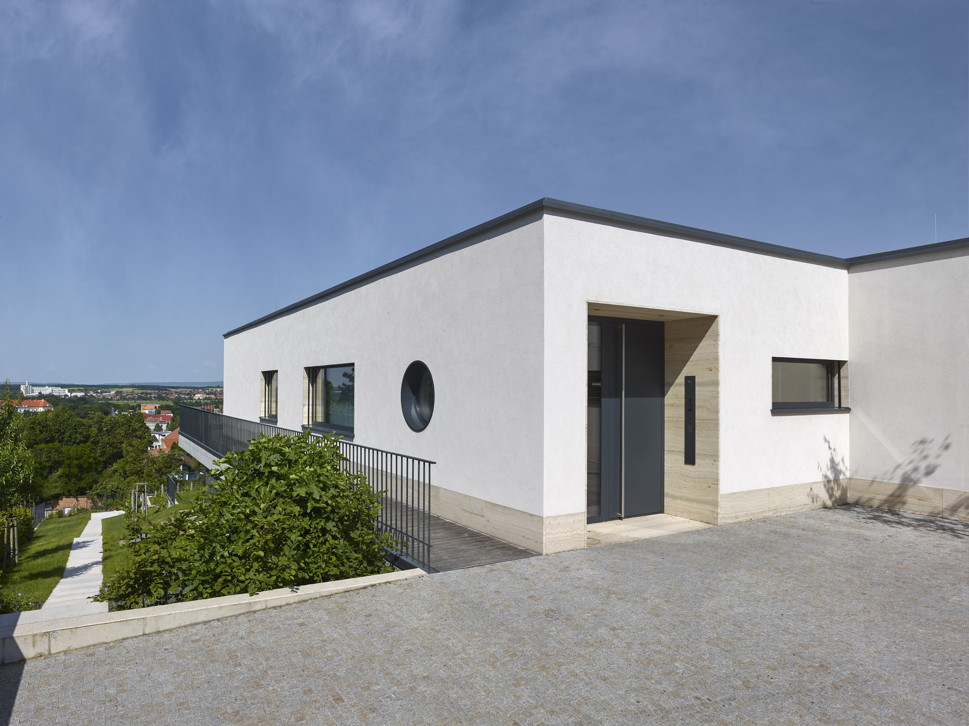 Vchod do vily obložený drahým kamenem.  (Vila zasazená do krajiny vinohradu; Atelier RAW)