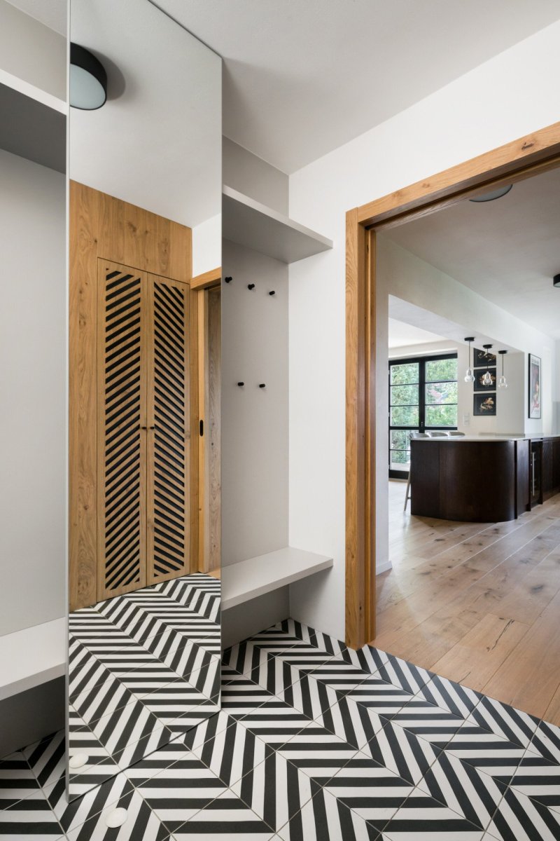 Rekonstrukce řadového domu u letiště, No Architects: Spojujícím znakem dřevěných prvků se stal dekor v podobě zrcadlově se opakujících diagonálních perforací ve dřevě a důmyslně provedený řemeslný detail