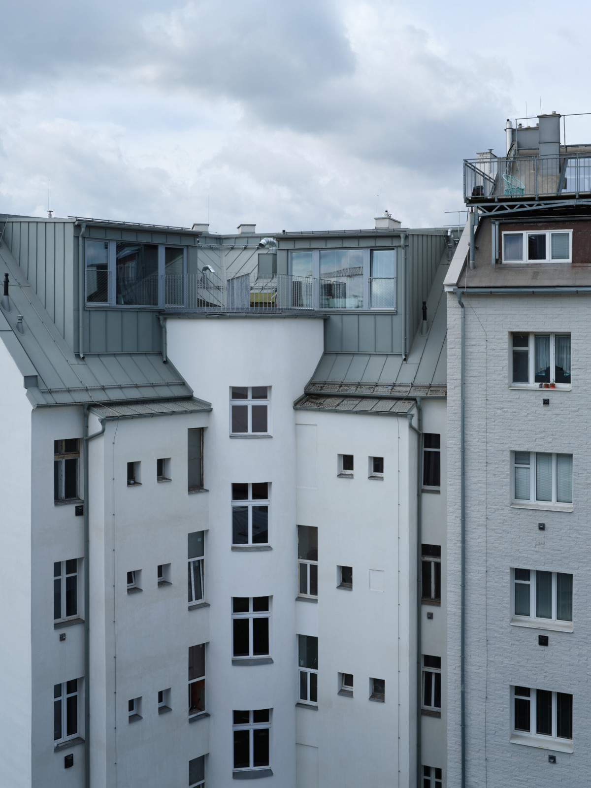 Dva mezonety se do tichého dvora otevírají velkorysými vikýři. (Nástavba Harfa; matěj šebek architekti)
