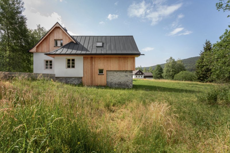 „Použité materiály vychází z historického objektu, ve kterém bylo použity dřevo, kámen a omítka,“ říká k tomu architekt Karel Harazim. (Chata Lipka na Šumavě, Harazim Karel Architektura)