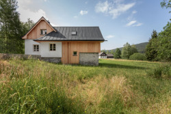 „Použité materiály vychází z historického objektu, ve kterém bylo použity dřevo, kámen a omítka,“ říká k tomu architekt Karel Harazim. (Chata Lipka na Šumavě, Harazim Karel Architektura)
