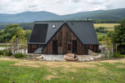 Venkovní zpevněné plochy jsou převážně dlážděny žulovými odseky z mrákotínského lomu, které plynule navazují na opěrné zídky skládané na sucho místními kameníky. (OK PLAN ARCHITECTS, Rodinná bouda)