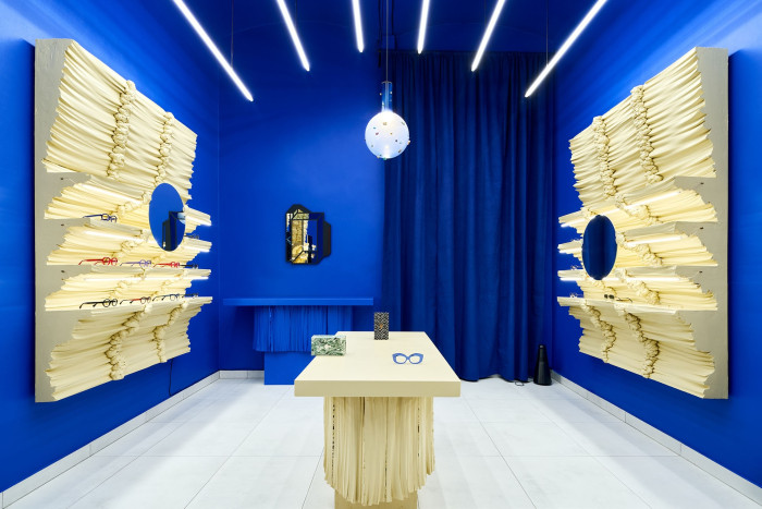 Světlé regály z montážní pěny a polystyrenu jsou v kontrastu s výraznou modrou barvou. (Optika Kahotski Eyewear Studio na Letné, IHOR) - výřez z fotografie