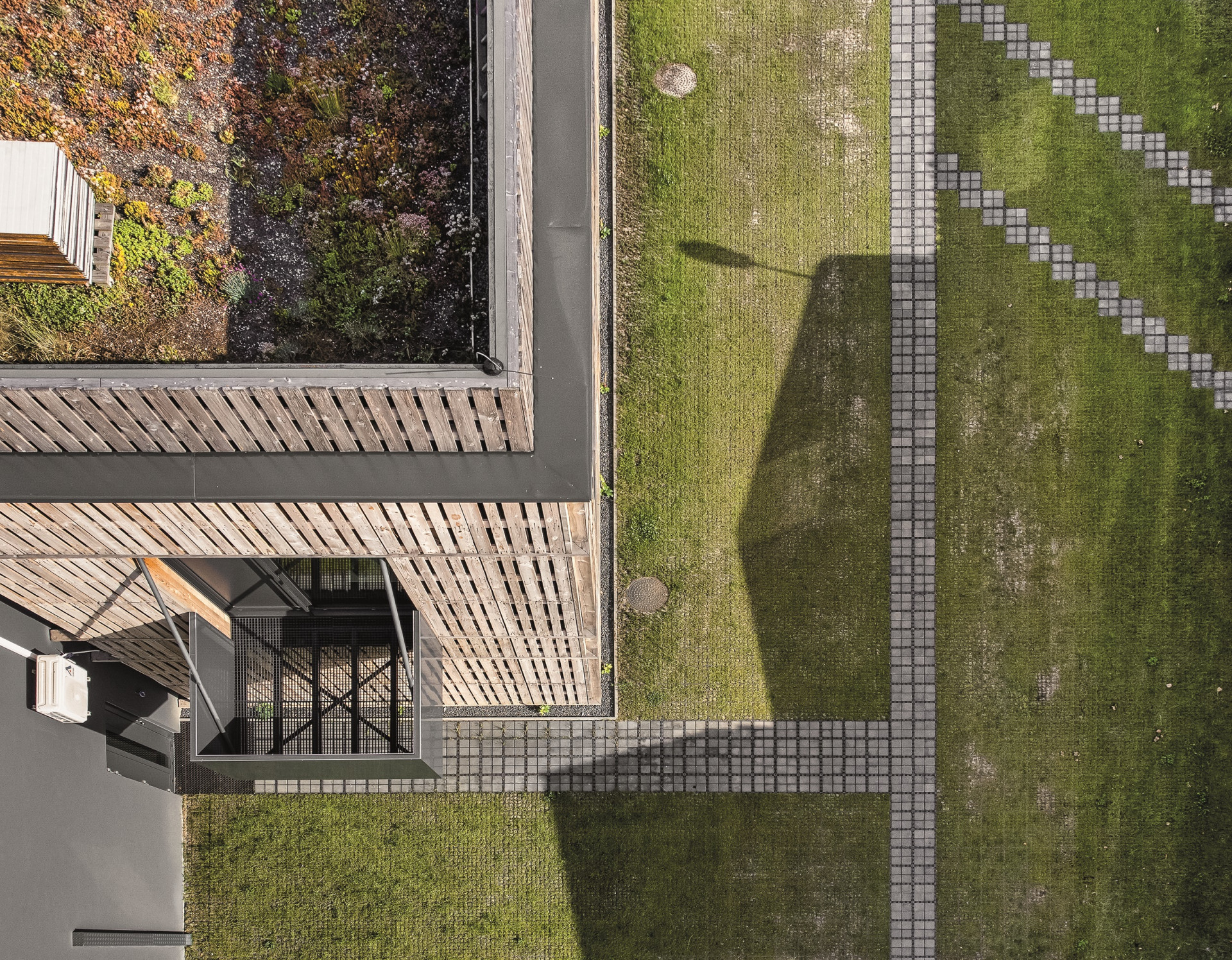 V rámci projektu se řešilo hospodaření s dešťovou vodou. Její zasakování umožňuje jak střecha tak zatravňovací dlažba. (Administrativní budova Fortemix v Paskově od PROJEKTSTUDIO)