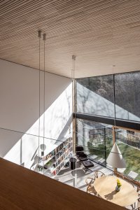 Celá stěna je přes obě podlaží, prosklená a interiér je plný světla. (Dům Devín, plusminusarchitects)