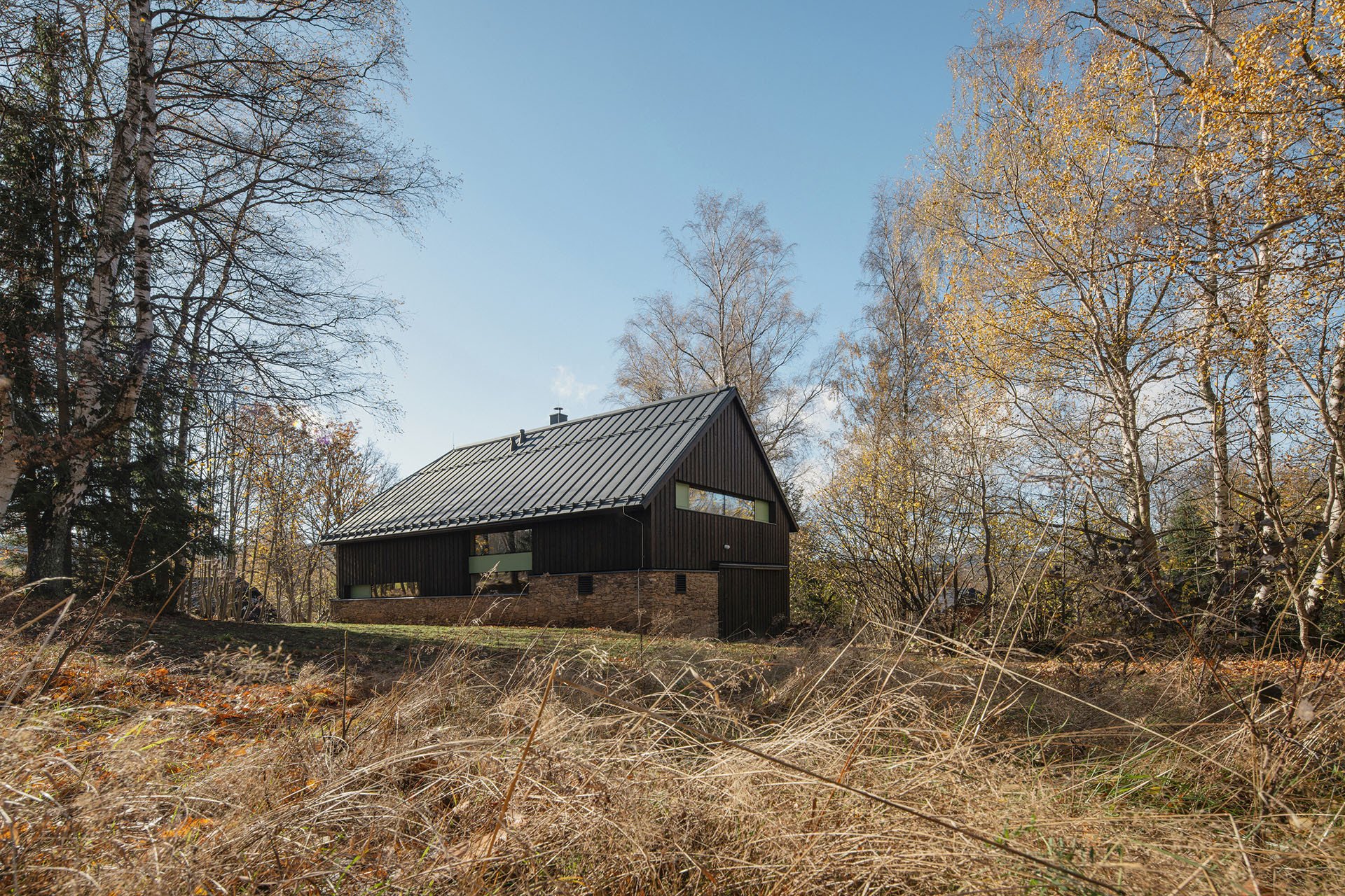„Uplatnily se zdejší tradiční znaky jako šířkovitost stavby, usazení rovnoběžně s vrstevnicemi, minimální terénní úpravy," říkají architektky. (Chata na Šumavě, ateliér Markéty Cajthamlové)