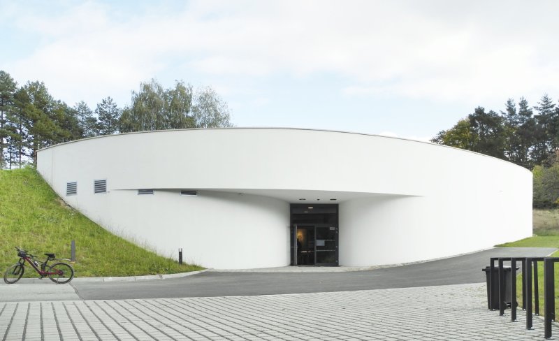 Za novým návštěvnickým centrem osady Ploština stojí studio Art Consultancy.