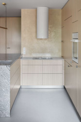 Hliněná omítka se slaměnou řezankou házející zlatavé odlesky je v barvě proschlé stepi. (Byt u Divoké Šárky v Praze, Iva Hájková Studio)