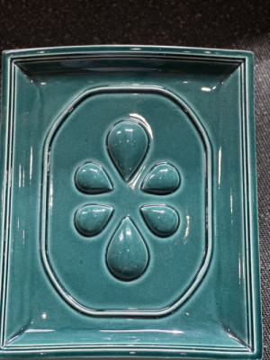 Logo resortu, které se propsalo na samotné kachle. (Rodinný resort Na peci, Lipno)