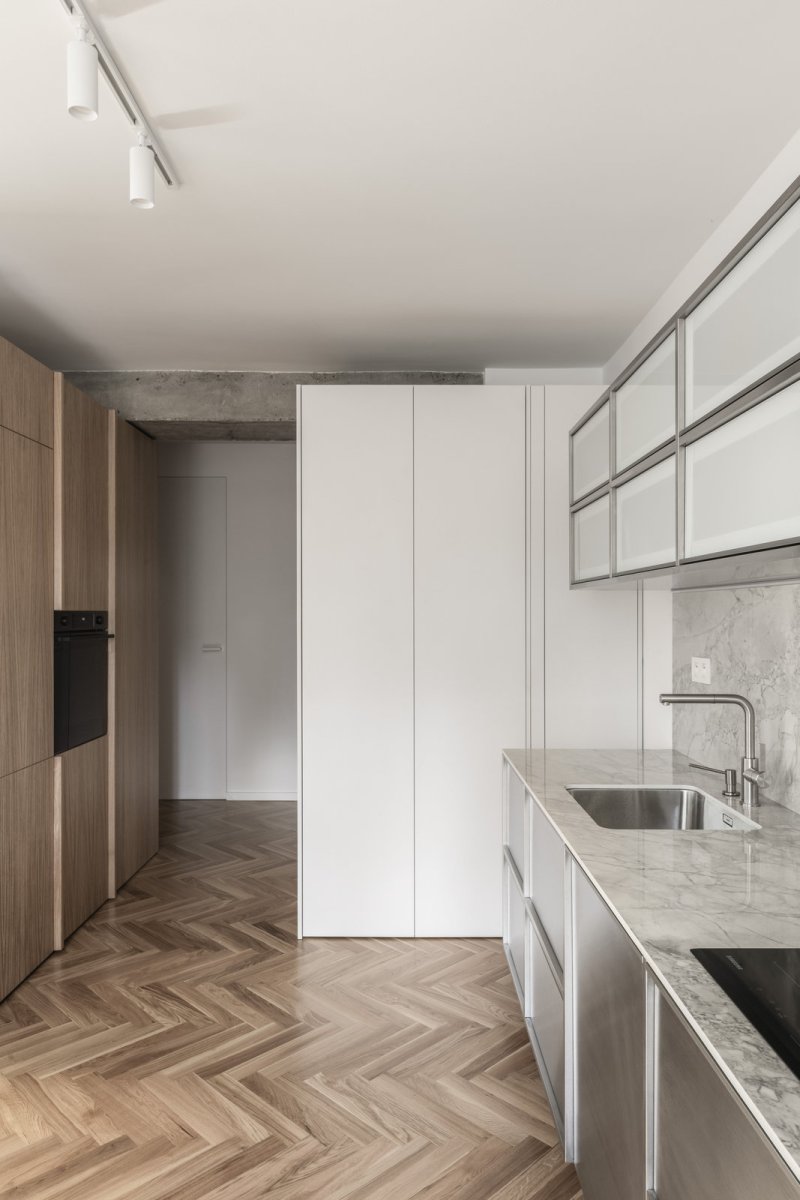 Kuchyňská linka je z nerezové oceli (Rekonstrukce bratislavského panelového bytu; Abrama architekti)