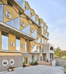 Hlavní prvkem fasády jsou kulatá okénka - původně pro obytné vozy. (Reggio škola v Madridu, Office for Political Innovation)