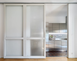 Byt Nusle, Amulet + T. Melková: Díky svému materiálu kuchyňská linka částečně zrcadlí okolí a světlo, čímž kuchyni bez okna opticky zesvětluje.