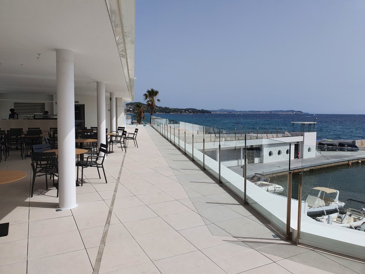 Hlavní budova klubu Club Nàutic Port d'Aro v Platja d'Aro se nachází přímo na promenádě v přístavu. Ze střešních teras třípatrové nízké budovy je jedinečný výhled na chráněnou zátoku s tyrkysově modrým mořem
