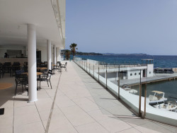 Hlavní budova klubu Club Nàutic Port d'Aro v Platja d'Aro se nachází přímo na promenádě v přístavu. Ze střešních teras třípatrové nízké budovy je jedinečný výhled na chráněnou zátoku s tyrkysově modrým mořem