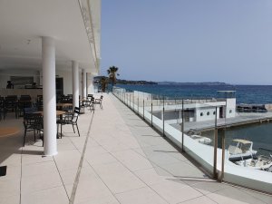 Hlavní budova klubu Club Nàutic Port d'Aro v Platja d'Aro se nachází přímo na promenádě v přístavu. Ze střešních teras třípatrové nízké budovy je jedinečný výhled na chráněnou zátoku s tyrkysově modrým mořem