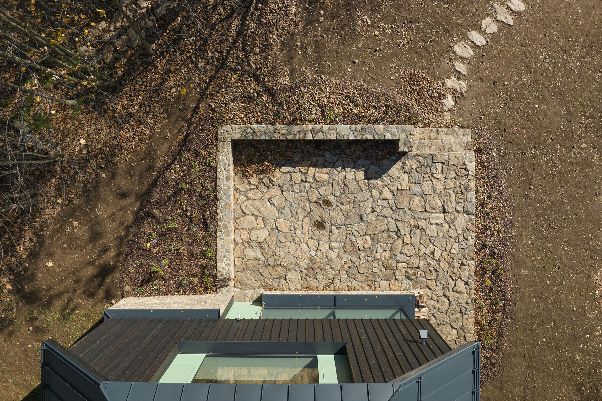 Terasy a podezdívky jsou vyskládané z lokálního kamene. (Chata na Šumavě, ateliér Markéty Cajthamlové)