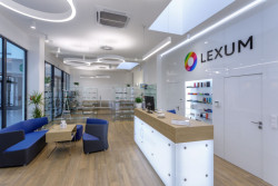 Bílá barva a sklo byly doplněny přírodním dekorem dřeva. (Optika CORNEA LEXUM v Praze)