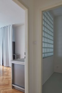 Stěna z luxfer je nová, ačkoliv vypadá, že tady mohla být už původně, k domu ze 30. let se hodí. - Byt v Praze na Letné, Prokop Hartl