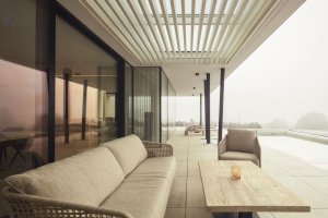 Kryté posezení s výhledem na bazén a krajinu propojuje interiér s exteriérem a podtrhuje klidnou atmosféru domu. (Bungalov ve východních Čechách; Atelier Kunc)