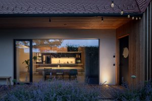 Pohled do kuchyně přes velké okno, které ji propojuje se zahradou (Rodinný dům v Břevnově; OTA atelier)