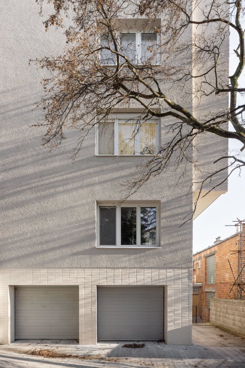 Rekonstrukce bytu a bytového domu Nový Svet, ARCHITEKTI mikulaj & mikulajová - Strukturovaná břízolitová omítka a světlý keramický obklad kabřince odkazují na charakter původních architektonických prvků